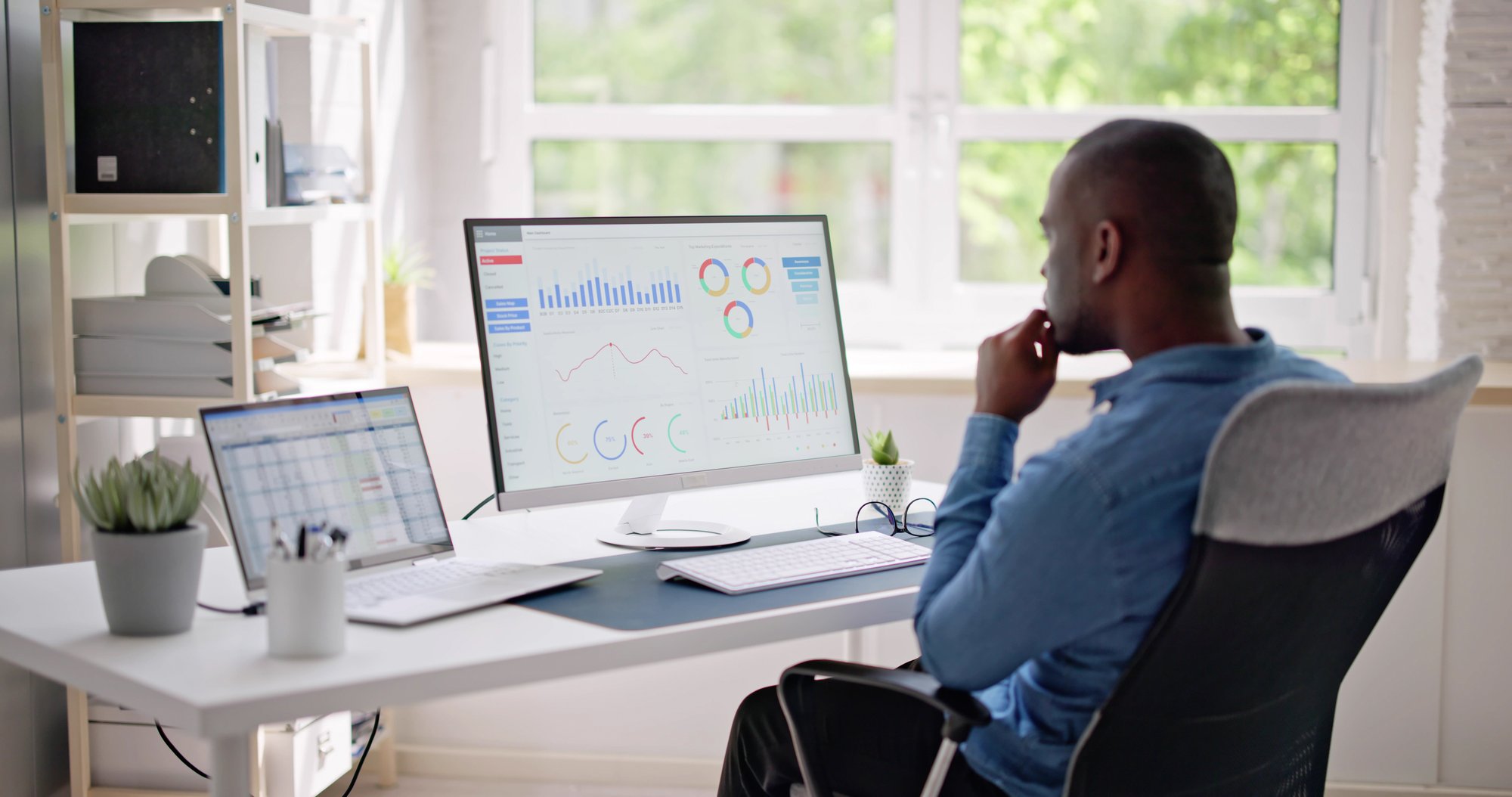 African-Businessman-Using-Analytics-Data-KPI-Dashboard-1493925417_4349x2293