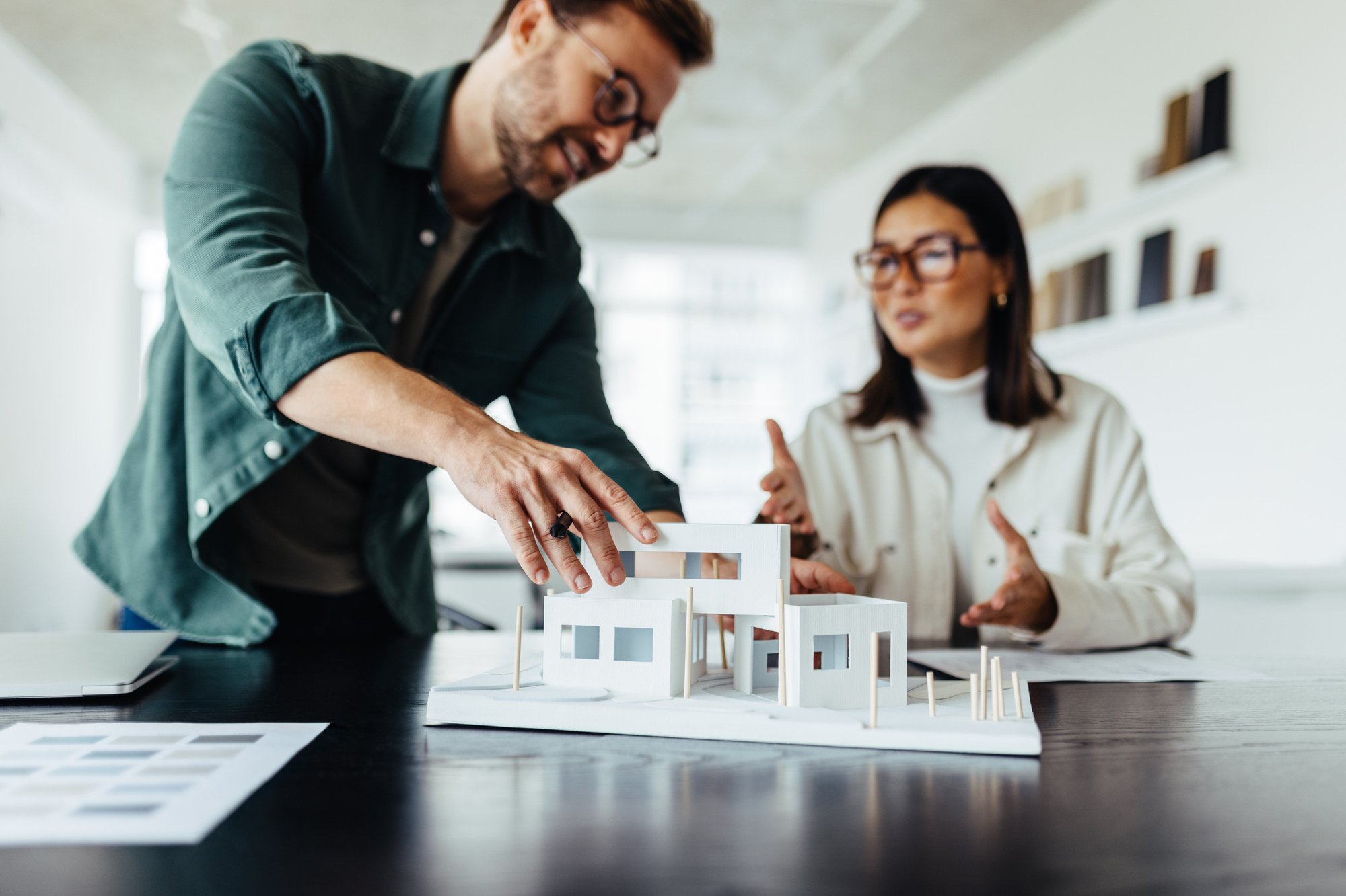 Architects-working-on-a-house-model-in-an-office-1502422431_2123x1416