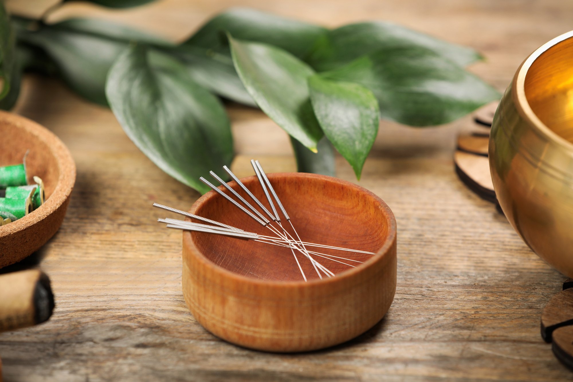 Bowl-with-acupuncture-needles-on-wooden-table-1453141064_2125x1416