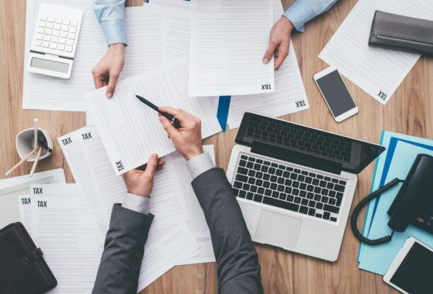 Business-people-checking-tax-forms-870747750_1256x838-613x416