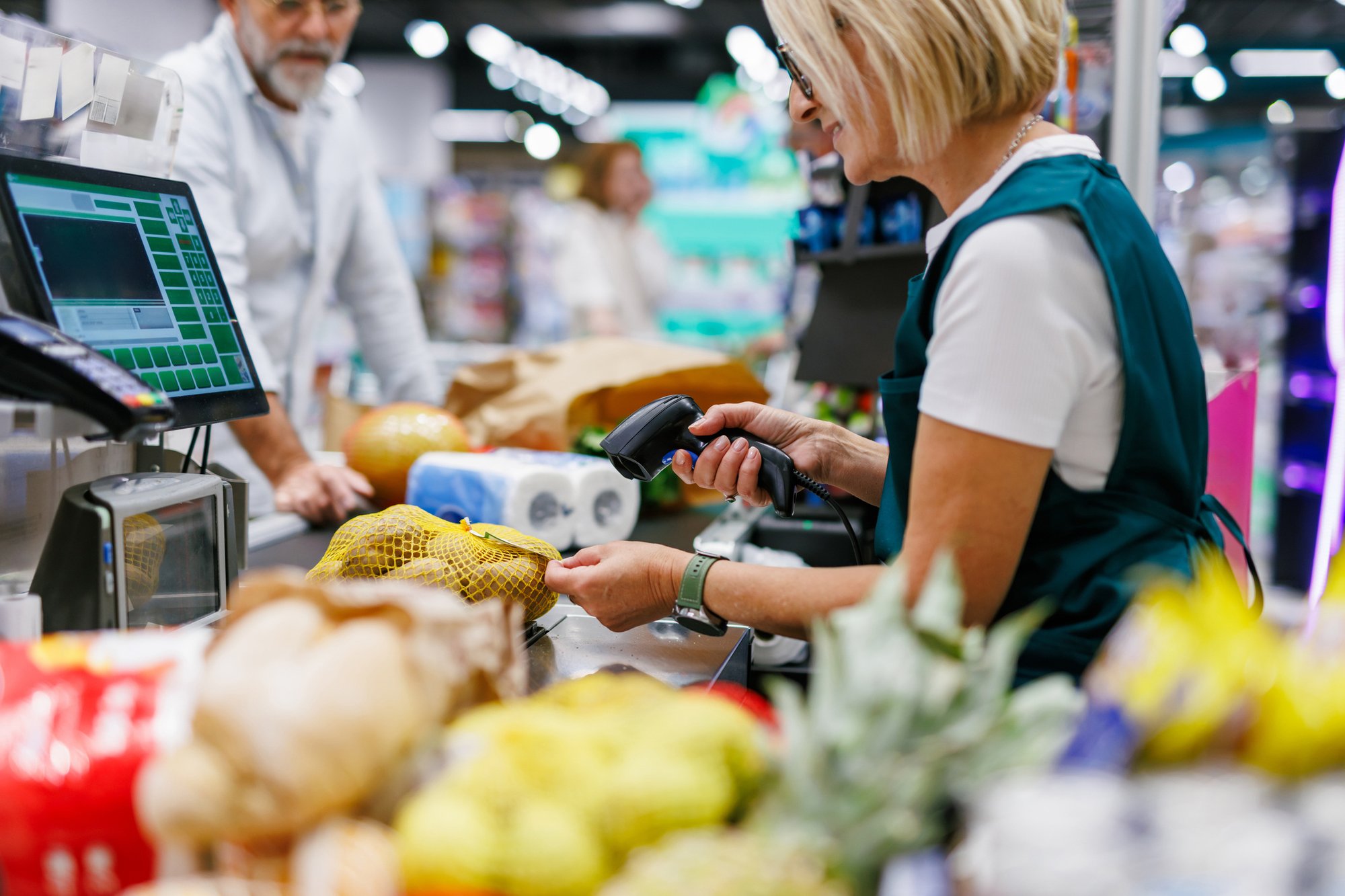 Cashier-scanning-groceries-at-the-supermarket-checkout-2186872091_2123x1416