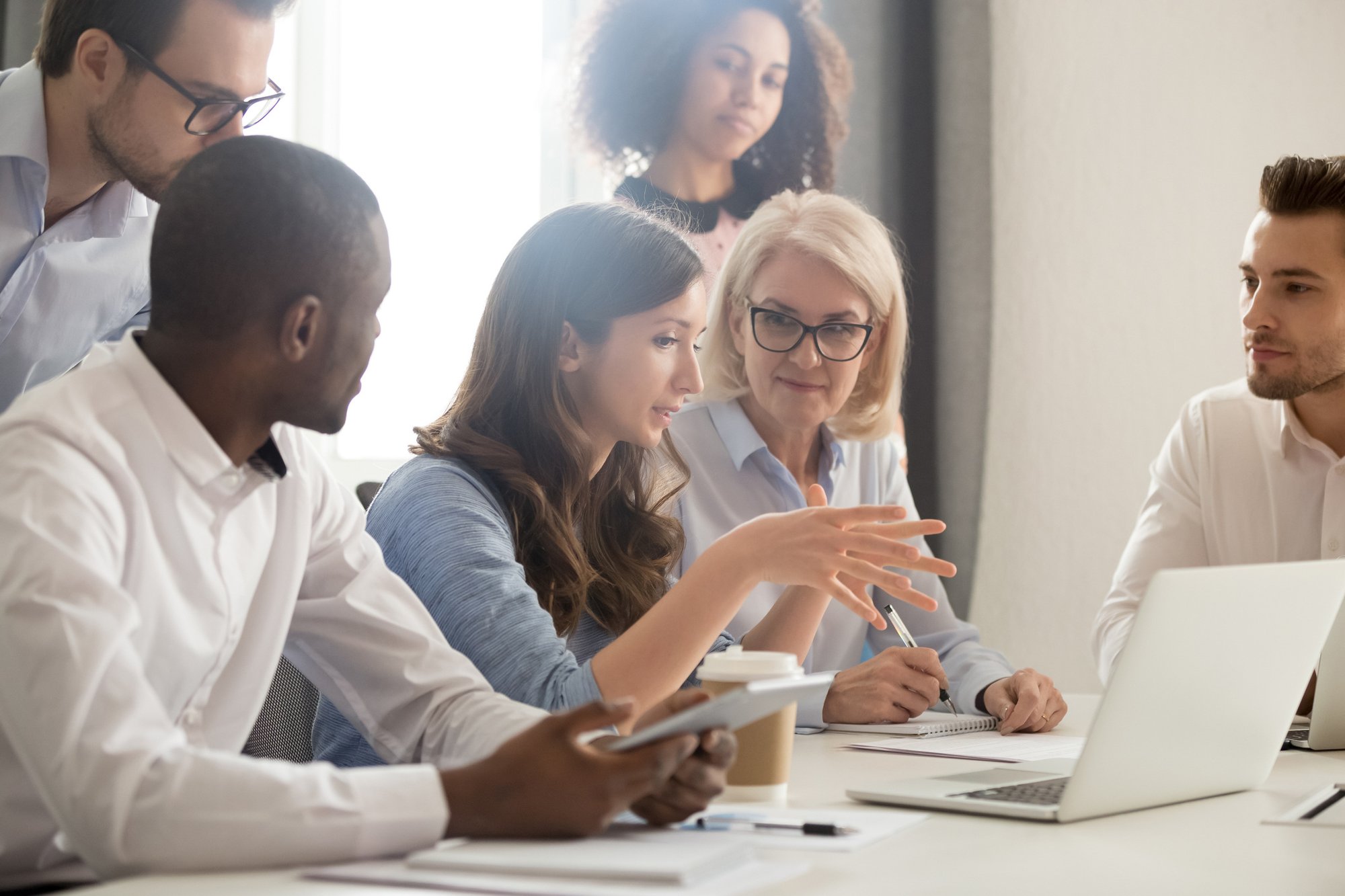 Female-mentor-teaching-employees-group-analyzing-online-project-explaining-strategy-1135346386_2125x1416