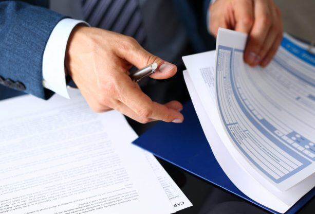 Male-arm-in-suit-offer-insurance-form-clipped-to-pad-857794116_1258x838-613x416
