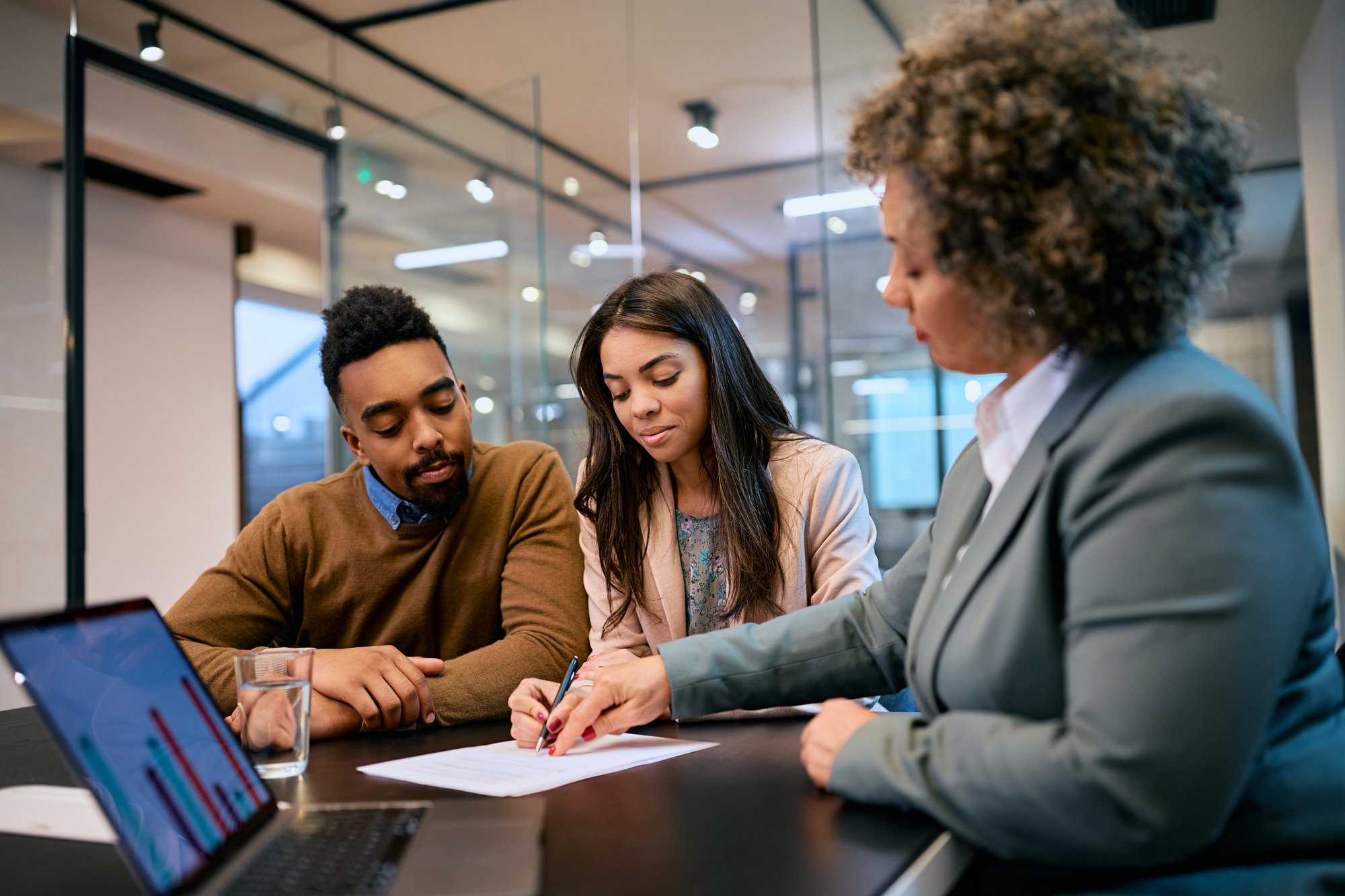 Young-black-couple-signing-a-contract-with-insurance-agent-in-the-office.-1483243964_3869x2579
