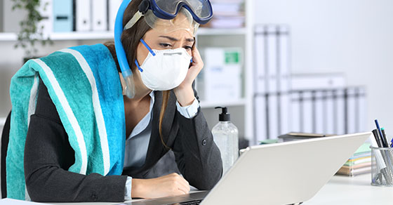 woman wearing scuba gear and a mask while looking at laptop