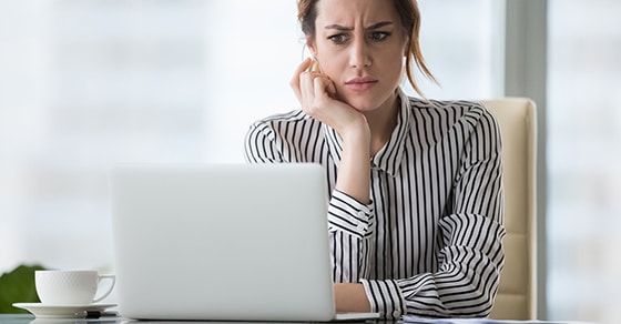 woman looking concerned at laptop