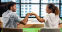 man and woman fistbump at business meeting
