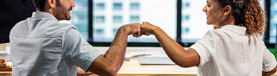 man and woman fistbump at business meeting