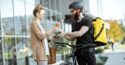 woman handing food to man on bike
