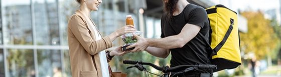 woman handing food to man on bike