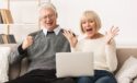excited older couple looking at laptop