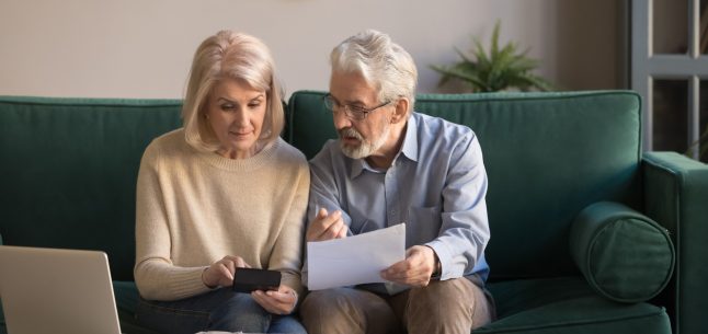 older couple looking at papers and calculator