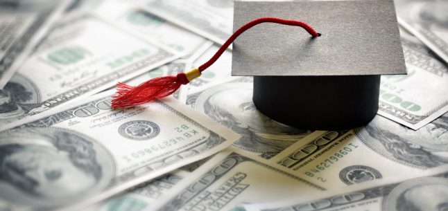 graduation cap on pile of $100 bills